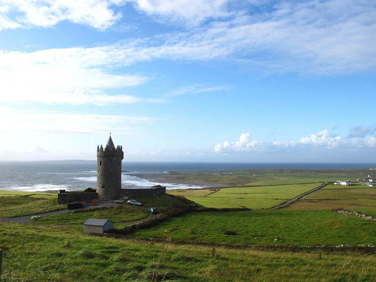 Doonagore Castle above Doolin with the Atlantic and green fields