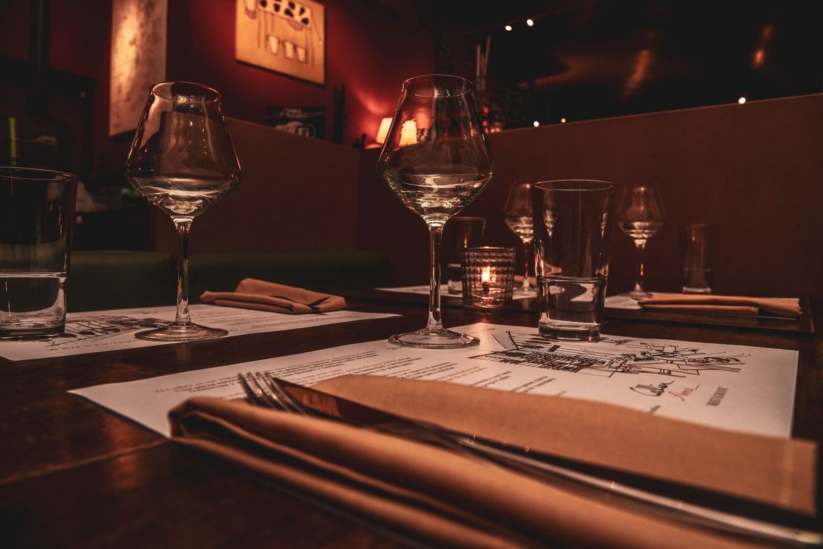 Candlelit table set with wine glasses in a dim romantic restaurant