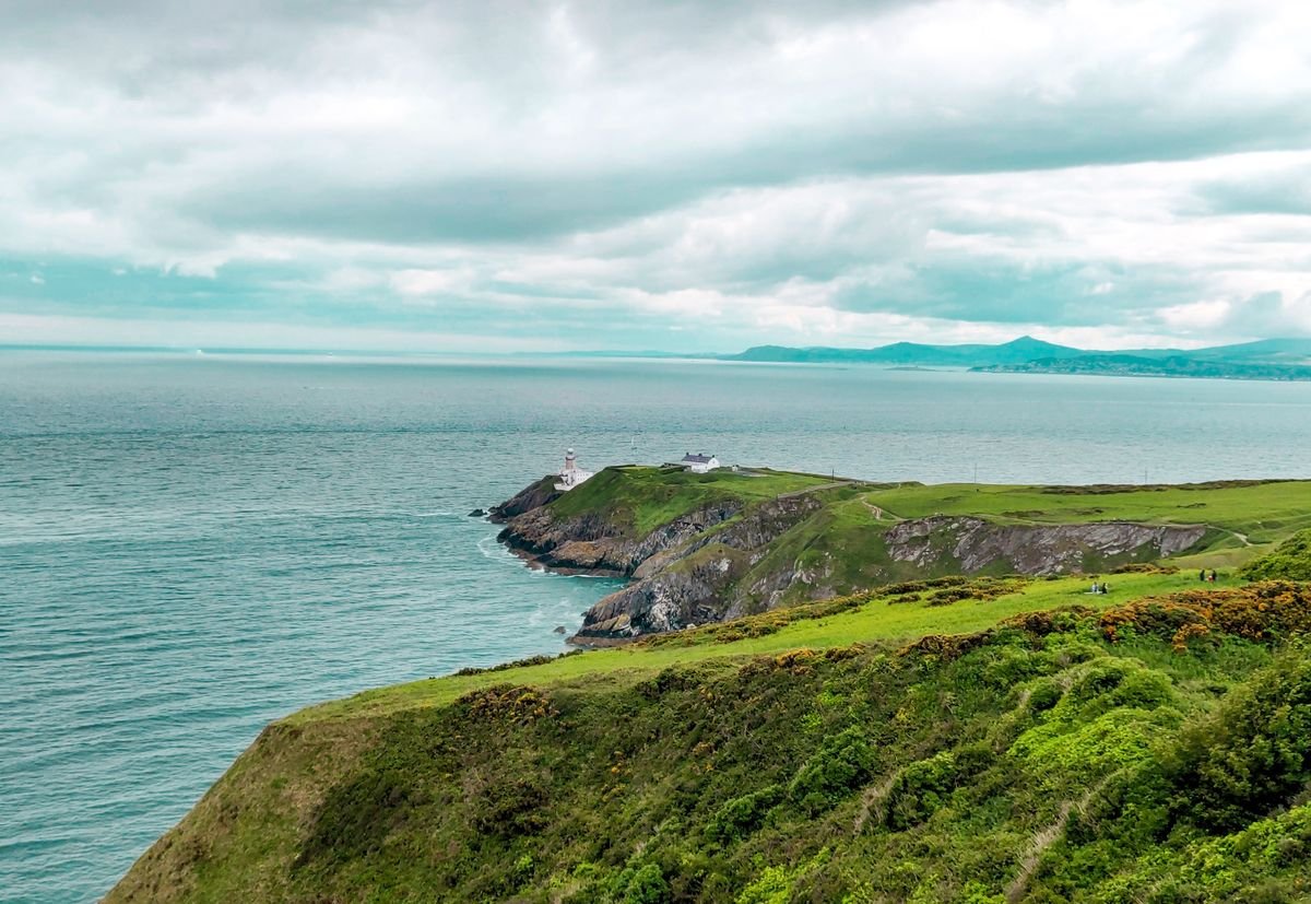 Green Irish coastal headland with a lighthouse