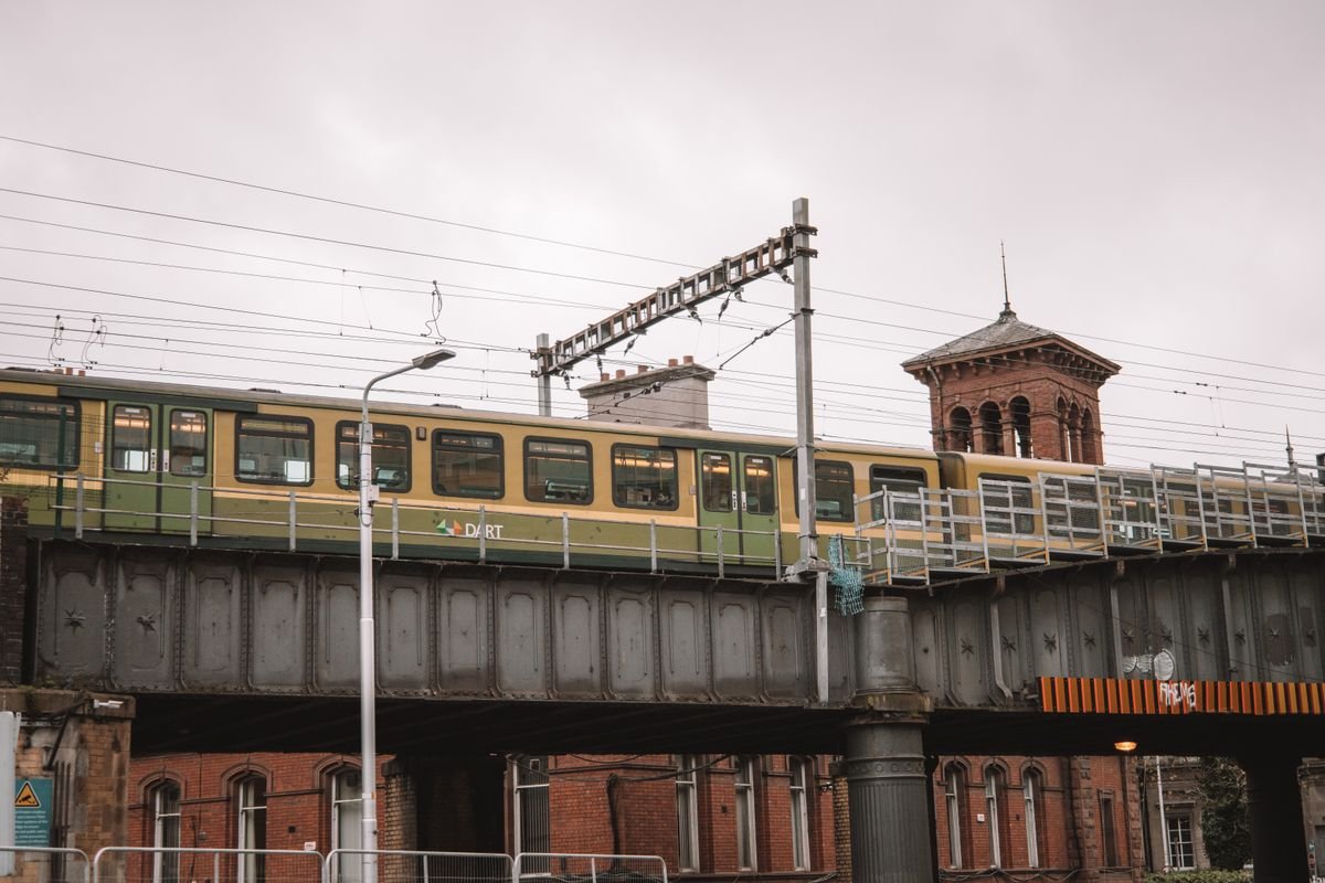 Green and cream DART commuter train on a viaduct in Dublin