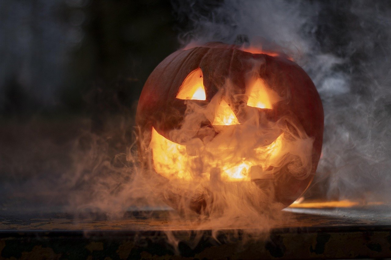 A glowing carved jack-o-lantern with smoke at night