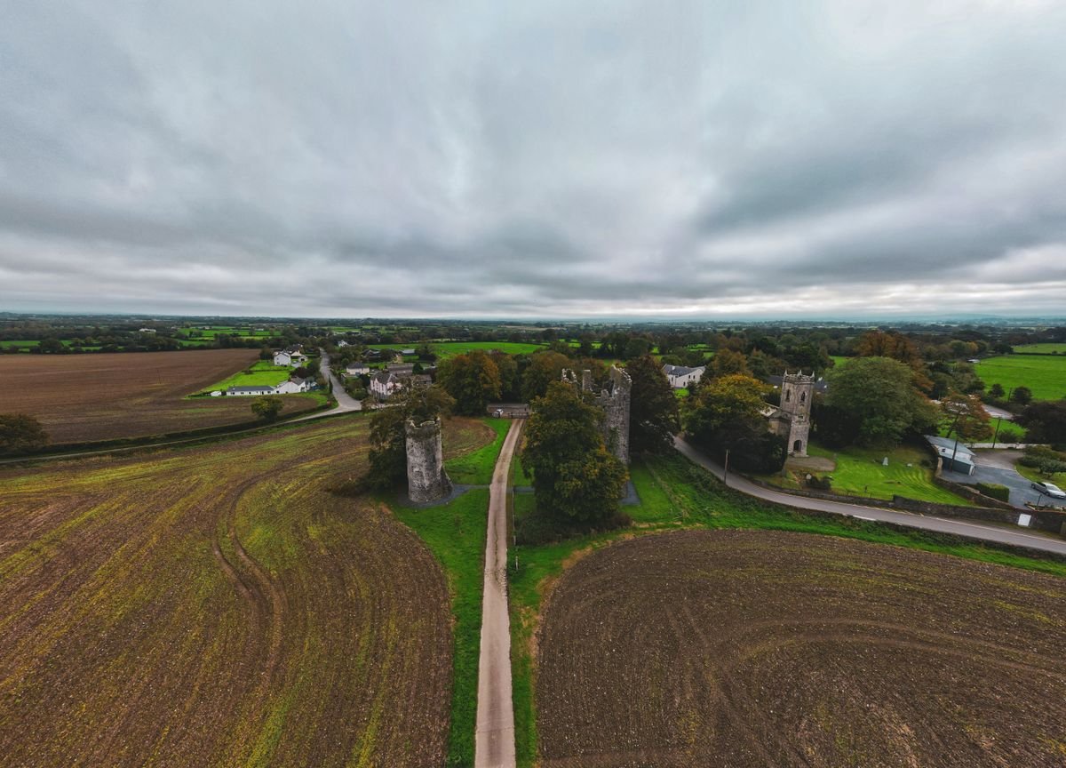 Aerial view of a ruined castle keep in the grey Irish countryside