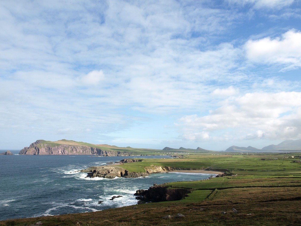 Green fields meeting the sea along the Irish coast