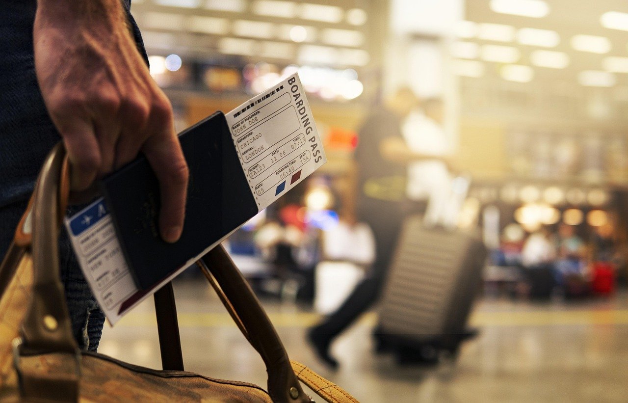 A traveler holding a passport and boarding pass at the airport