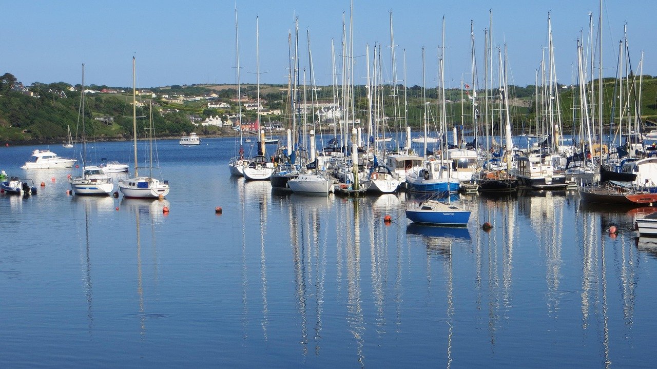 Sailboats moored in Kinsale harbour under a blue sky