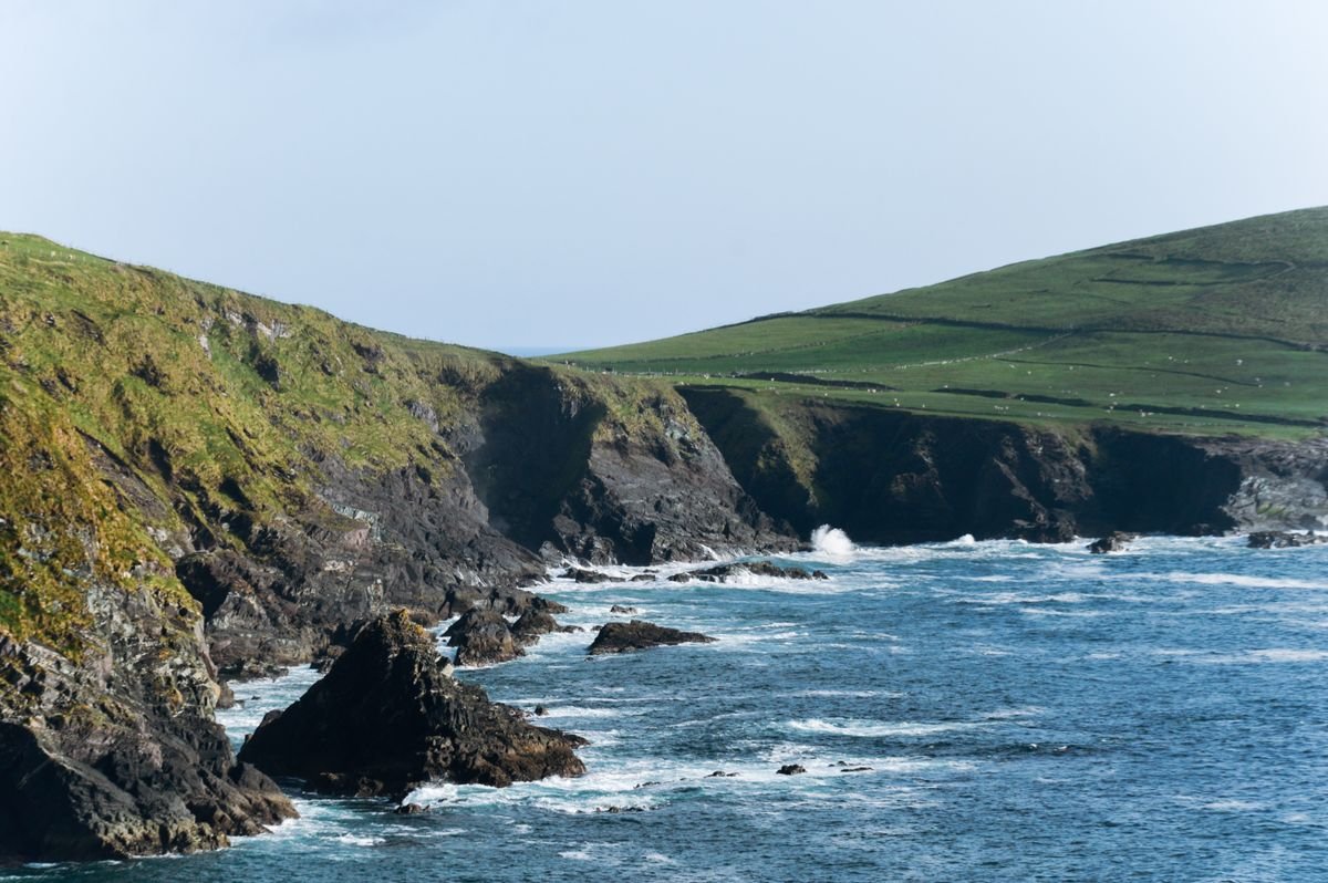 Cliffs and green fields meeting the sea on the Slea Head Drive in Dingle