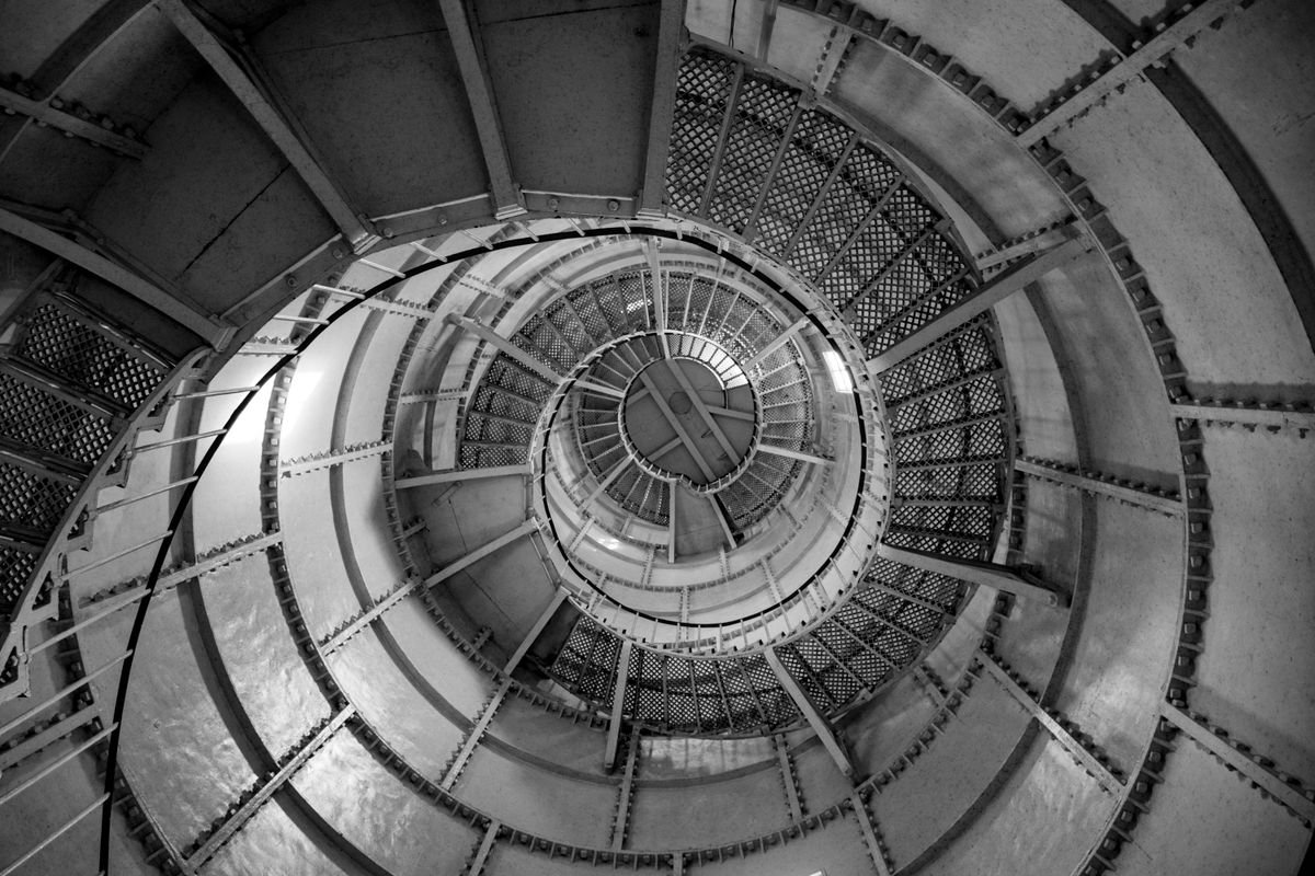 Looking up a spiral staircase inside a tall lighthouse tower
