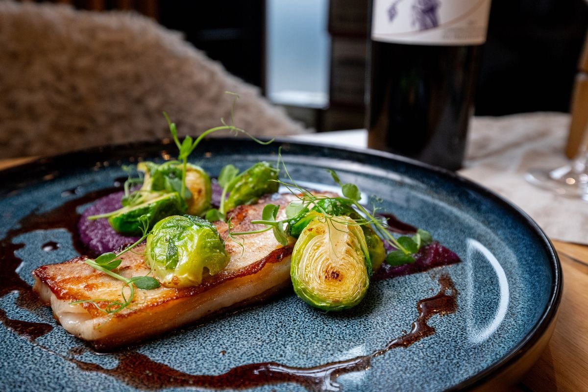 Plated fish dish with a glass of red wine at a Dublin restaurant