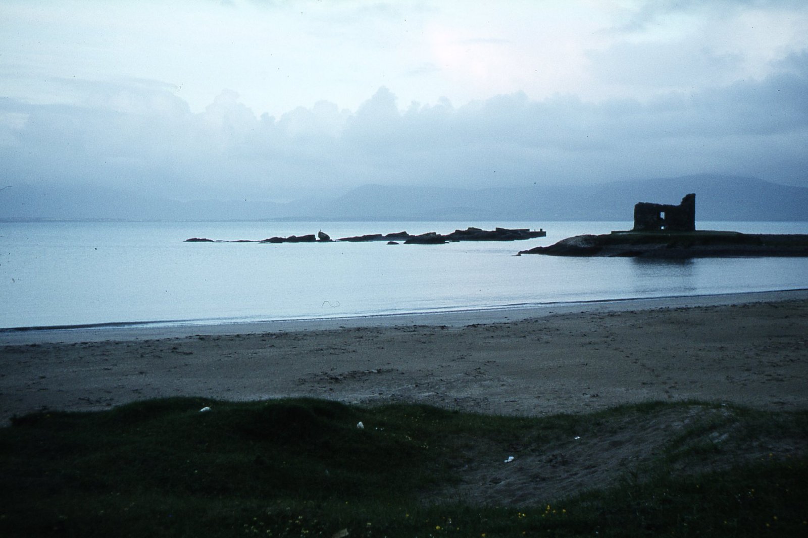Ballinskelligs beach with the ruined tower house at the water's edge