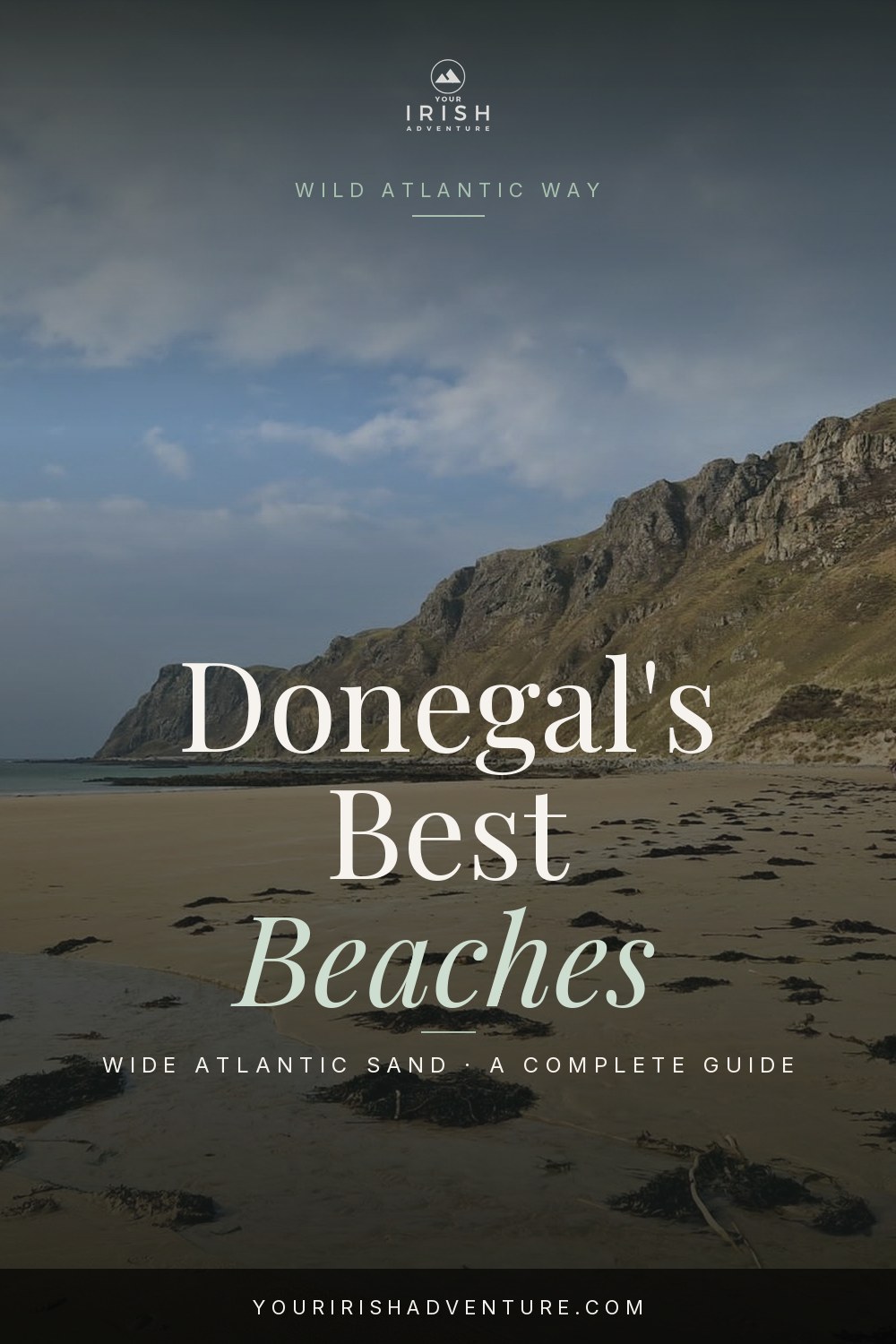 Empty wide sandy Atlantic strand backed by dunes under a blue sky in Donegal Ireland
