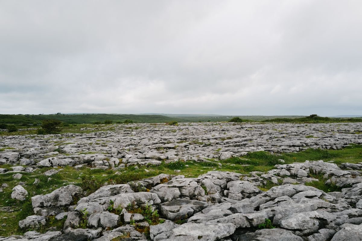 Bare grey limestone pavement of the Burren under a cloudy sky in County Clare