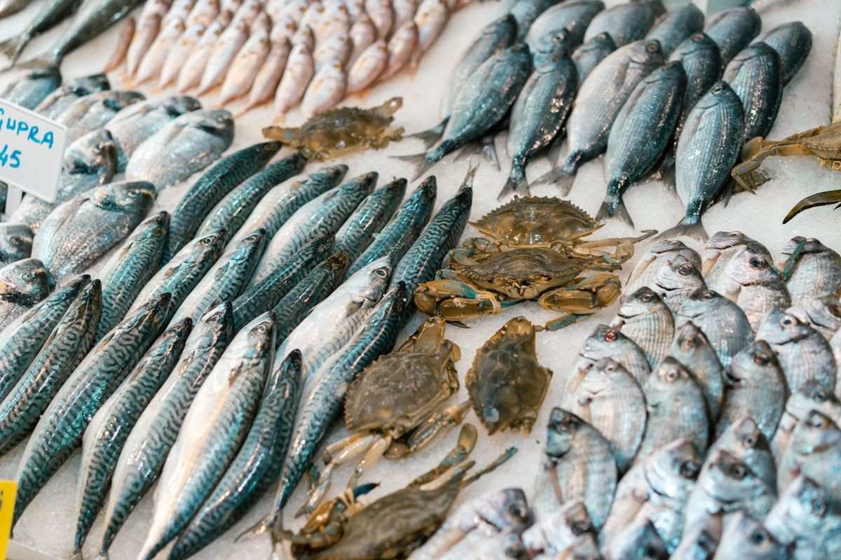 Fresh fish and crabs laid out on ice at a fishmonger counter