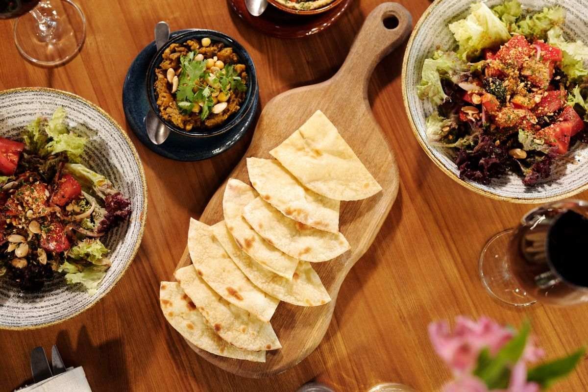 Spanish style tapas sharing plates with glasses of red wine on a wooden table