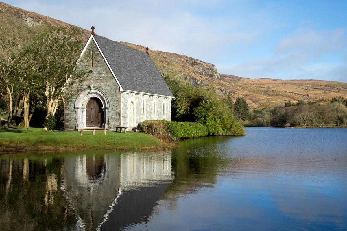 The stone oratory on the lake at Gougane Barra reflected in still water