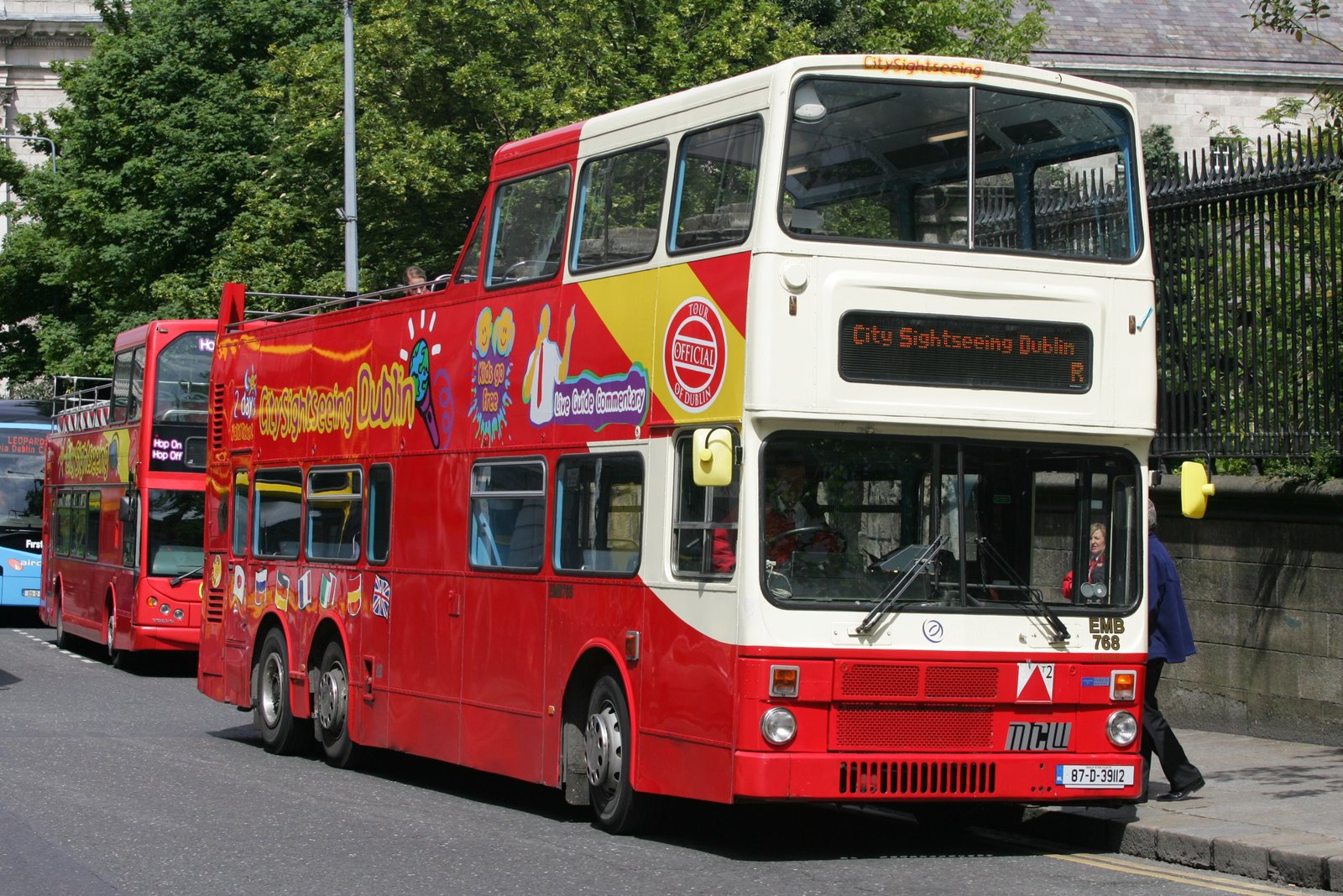 A red City Sightseeing Dublin hop-on hop-off bus on a city street