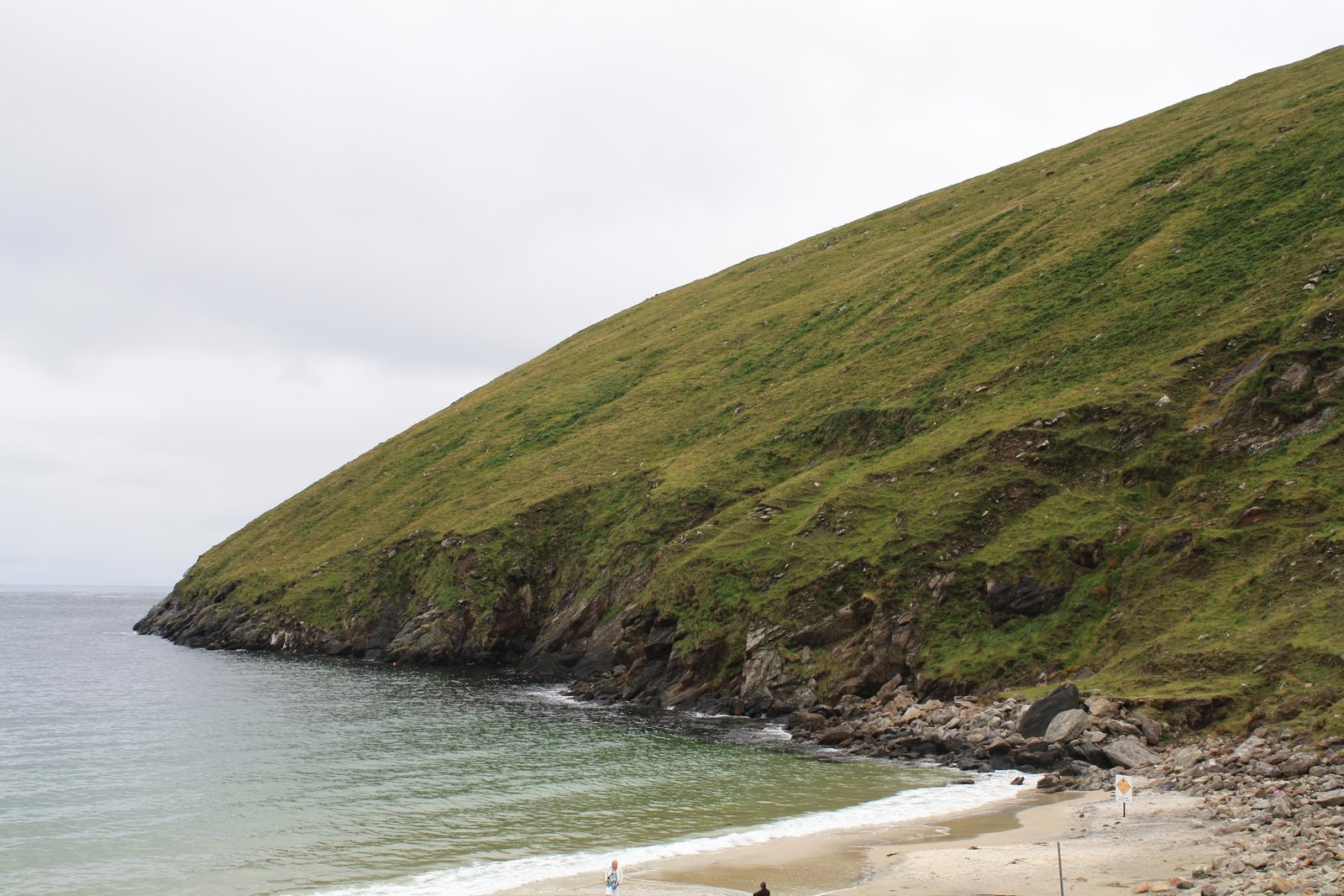 Green headland dropping to the sandy beach at Keem Bay on Achill Island