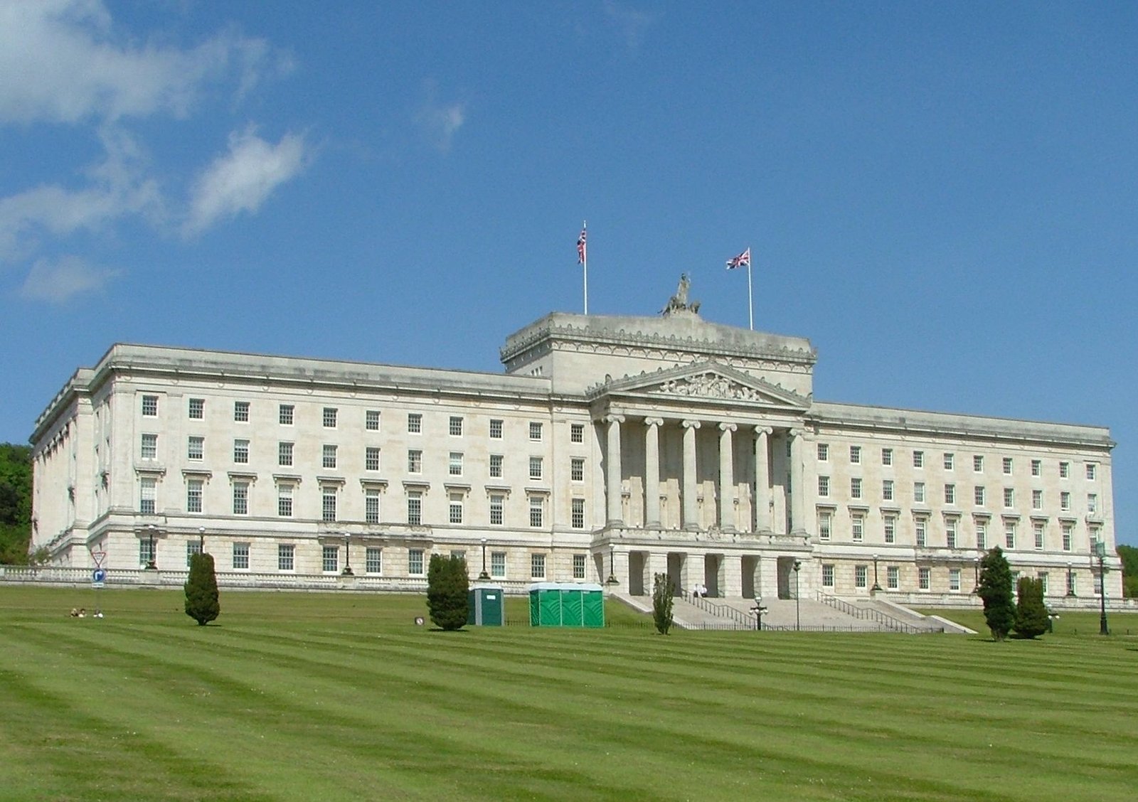 Parliament Buildings at Stormont, Belfast, seen across the front lawns under a blue sky