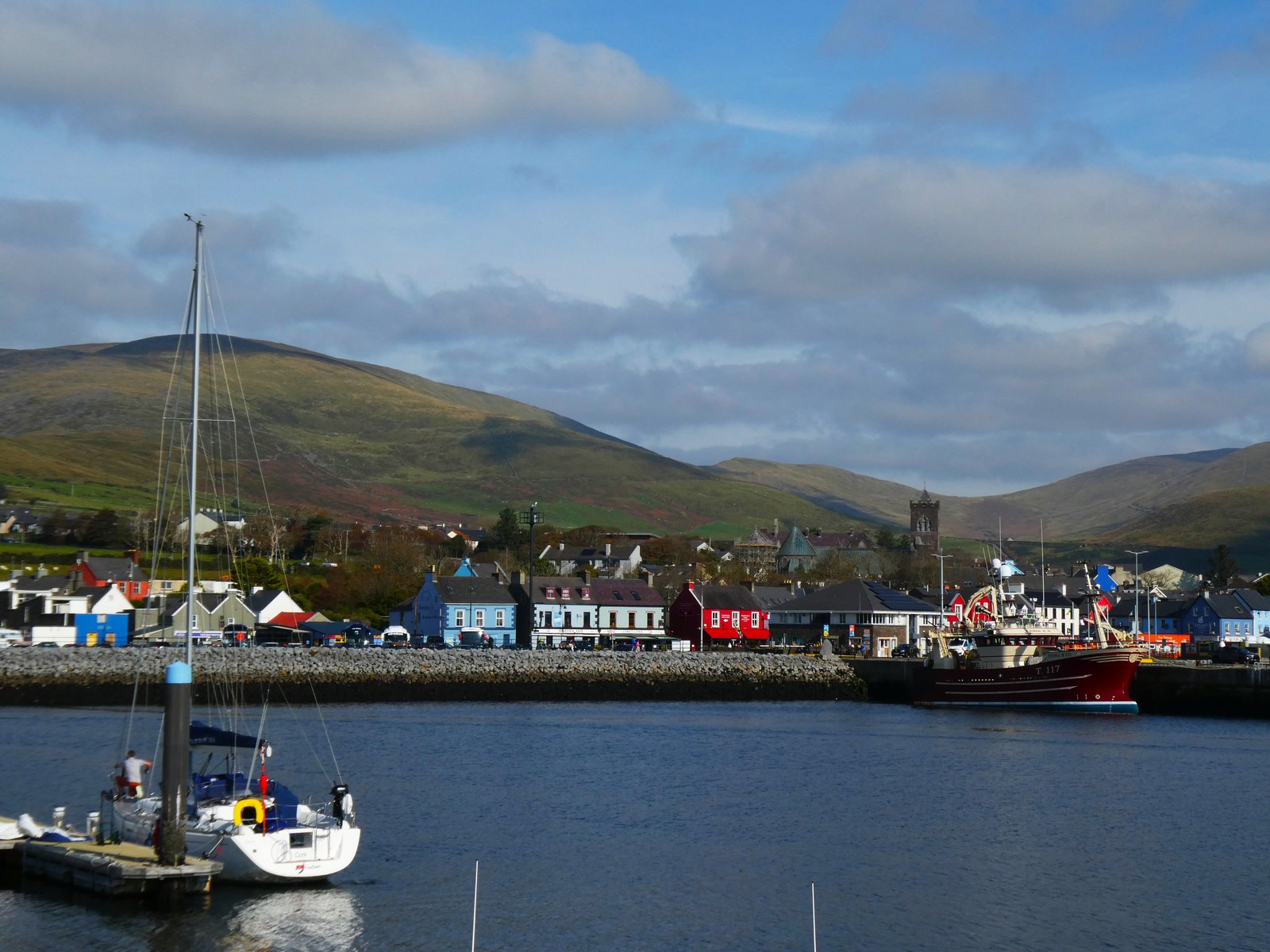 Boats in Dingle harbour with the painted town behind