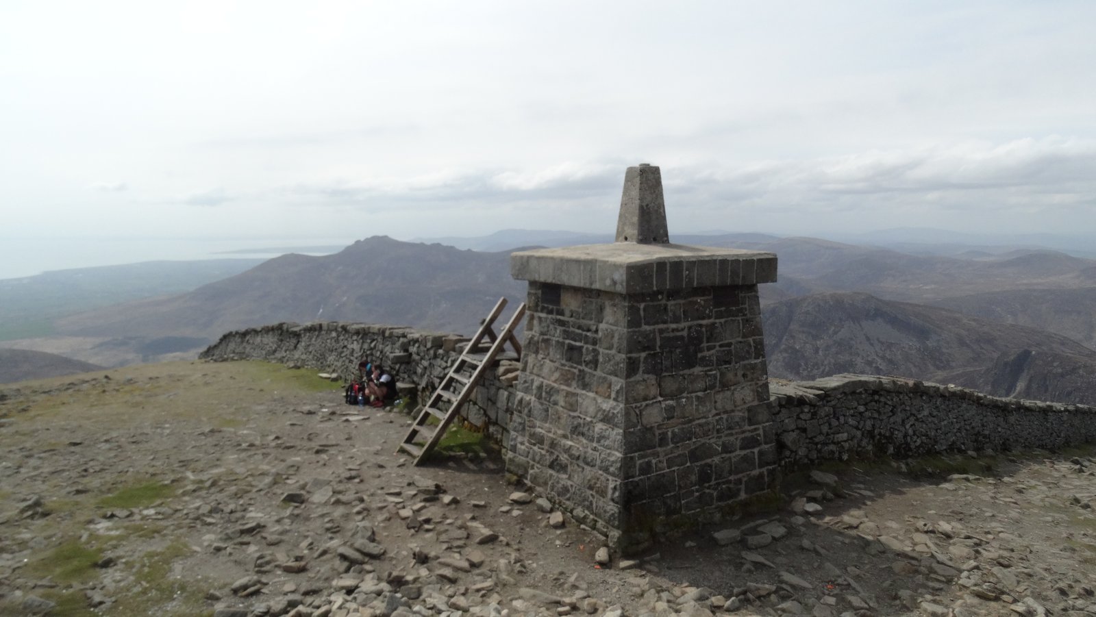 The stone trig pillar and Mourne Wall at the summit of Slieve Donard