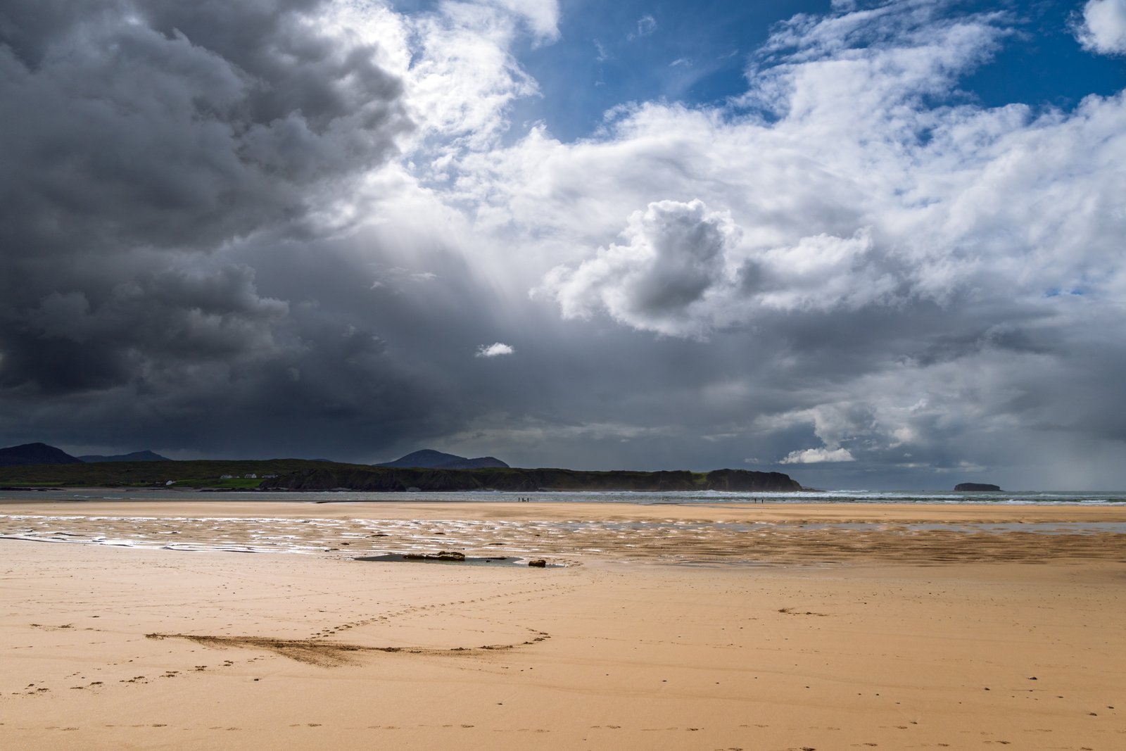 A wide Donegal strand under a dramatic Atlantic storm sky