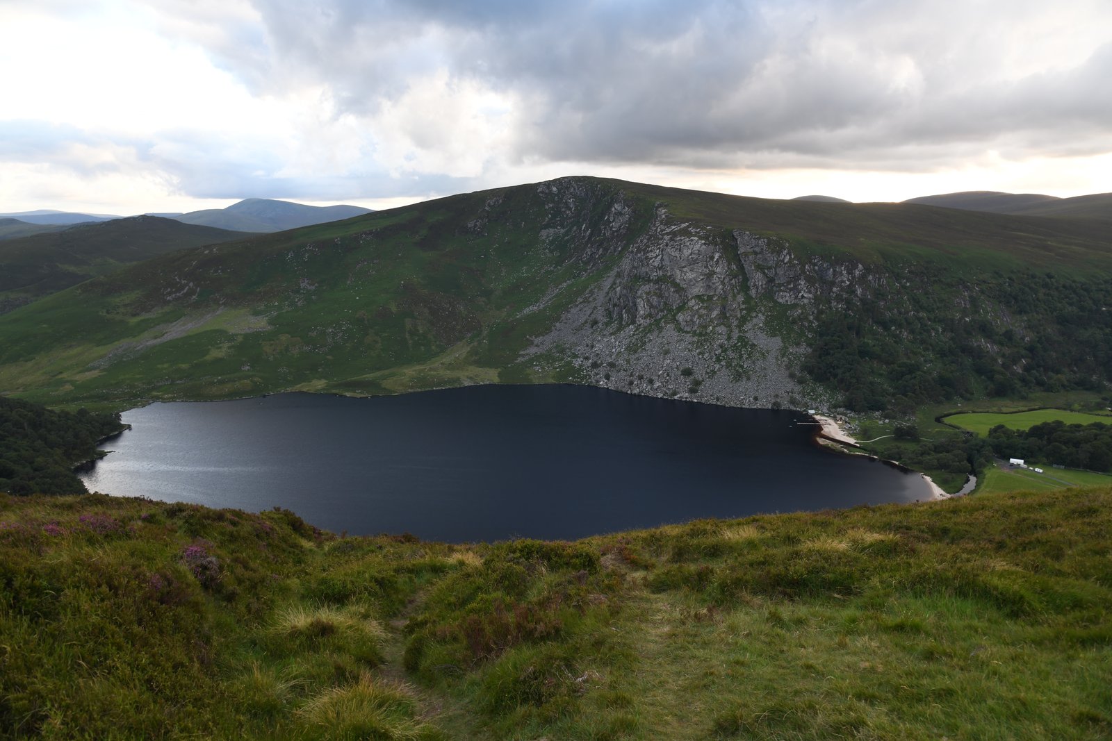 Lough Tay seen from the road above, the dark lake with its pale sand strip