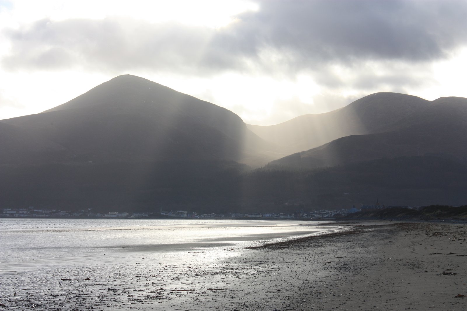 Sunlight breaking through cloud over the Mourne Mountains above Newcastle beach