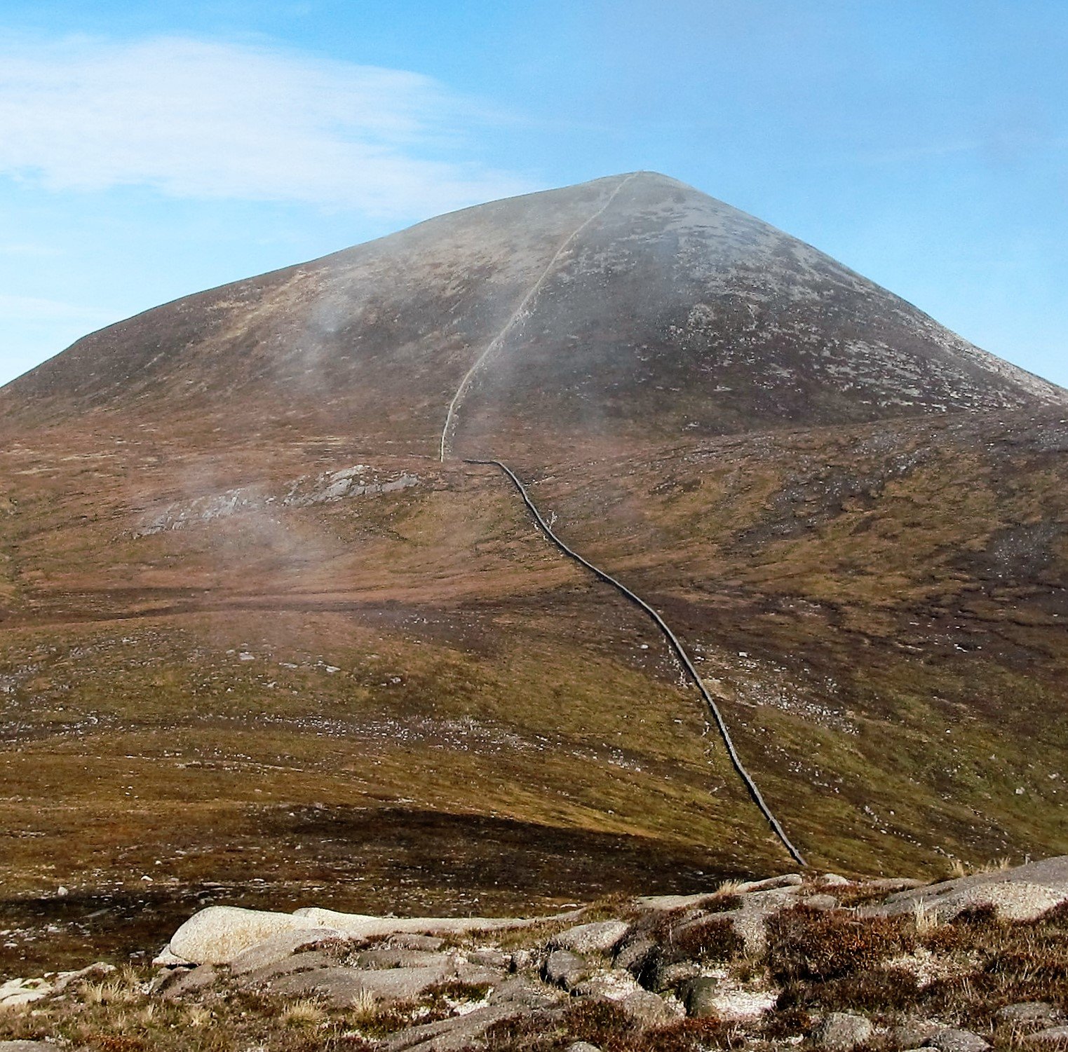 A path and wall climbing a peak in the Mourne Mountains