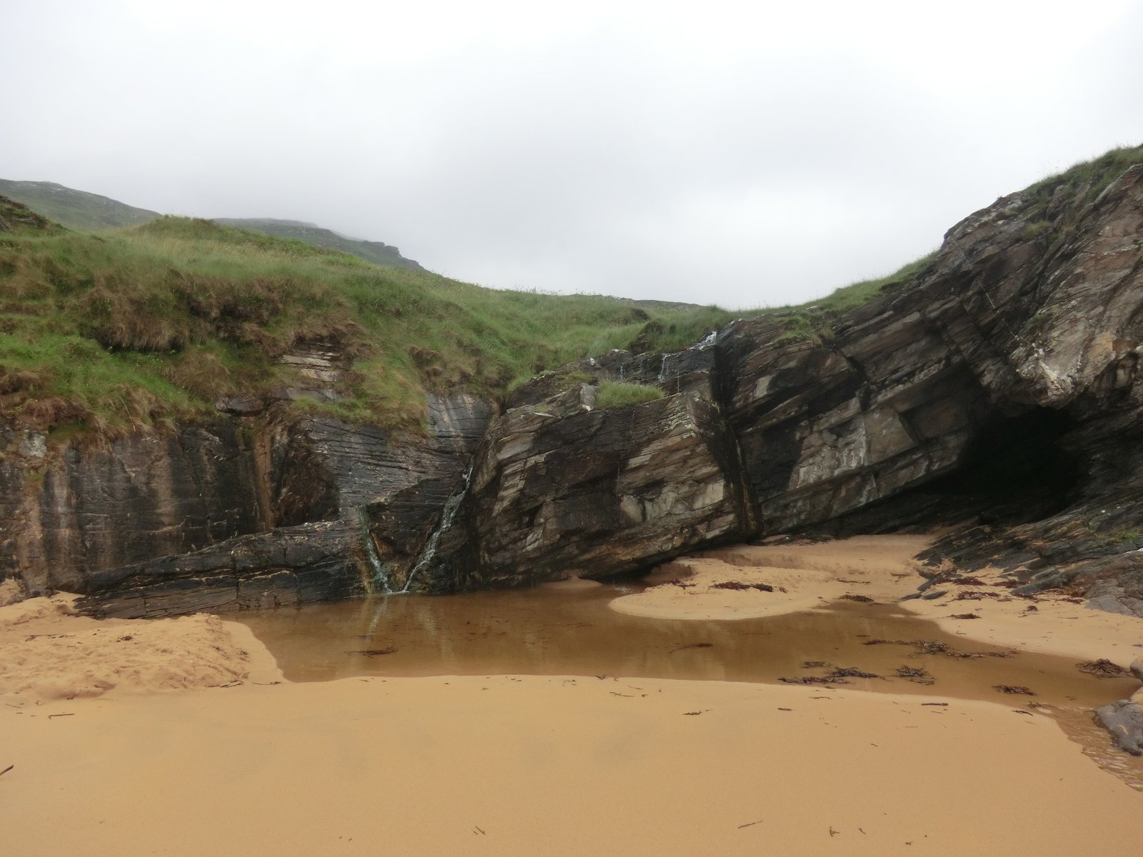 A rocky sea cave and waterfall on Maghera beach near Ardara, County Donegal