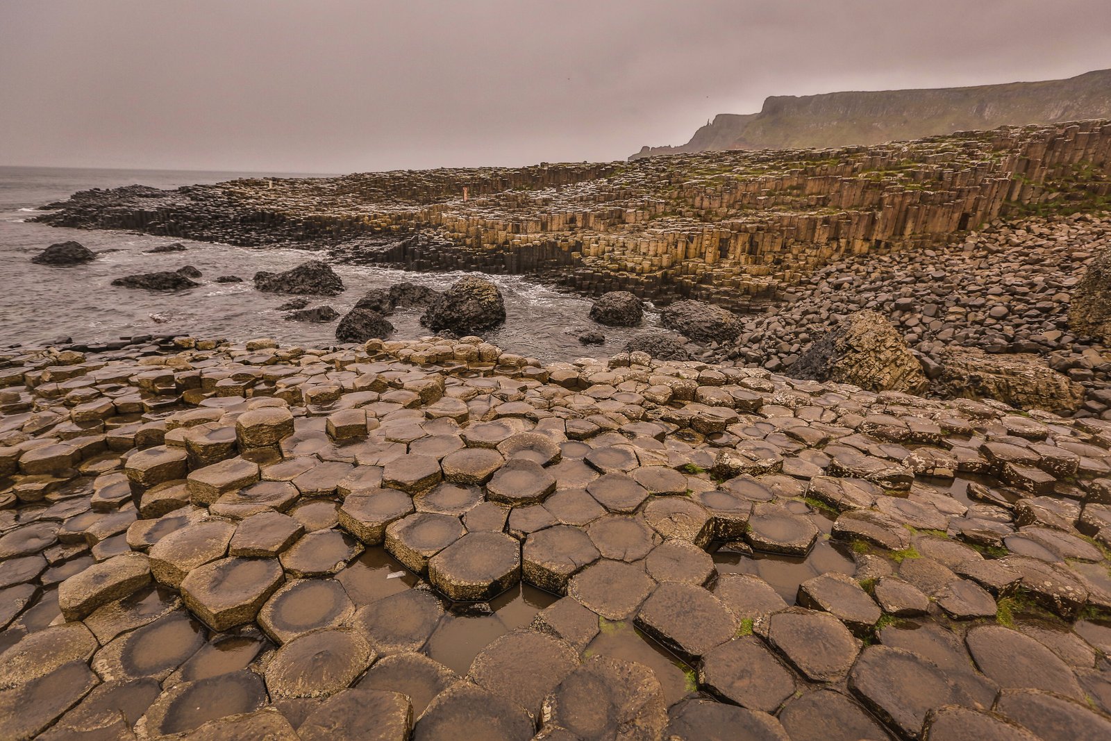 Hexagonal basalt columns of the Giant's Causeway meeting the sea in Northern Ireland