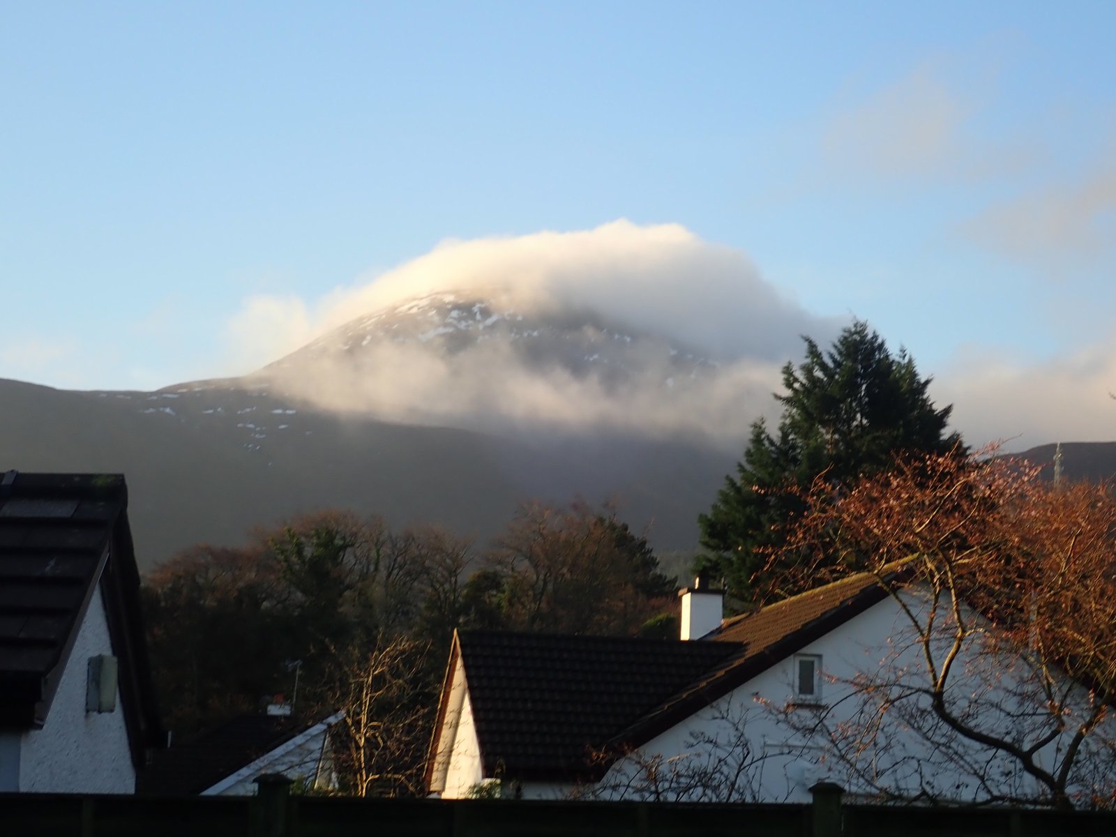 Cloud sitting on a Mourne summit above the rooftops of Newcastle