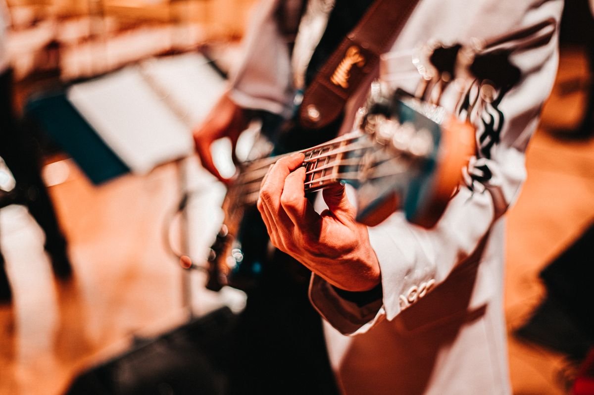 Musician playing acoustic guitar hands close up at a trad session