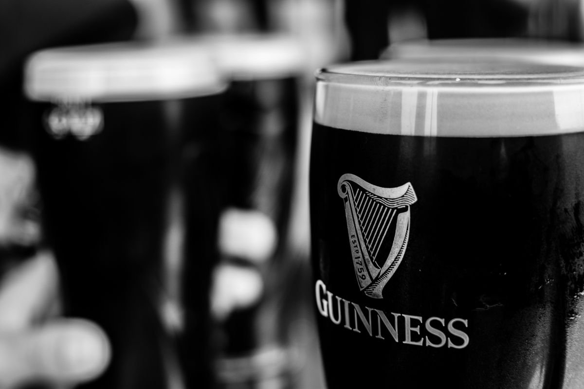 Pints of stout lined up on a bar in an Irish pub