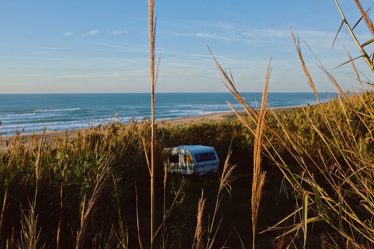 Campervan parked in dune grass above a beach on the Donegal coast
