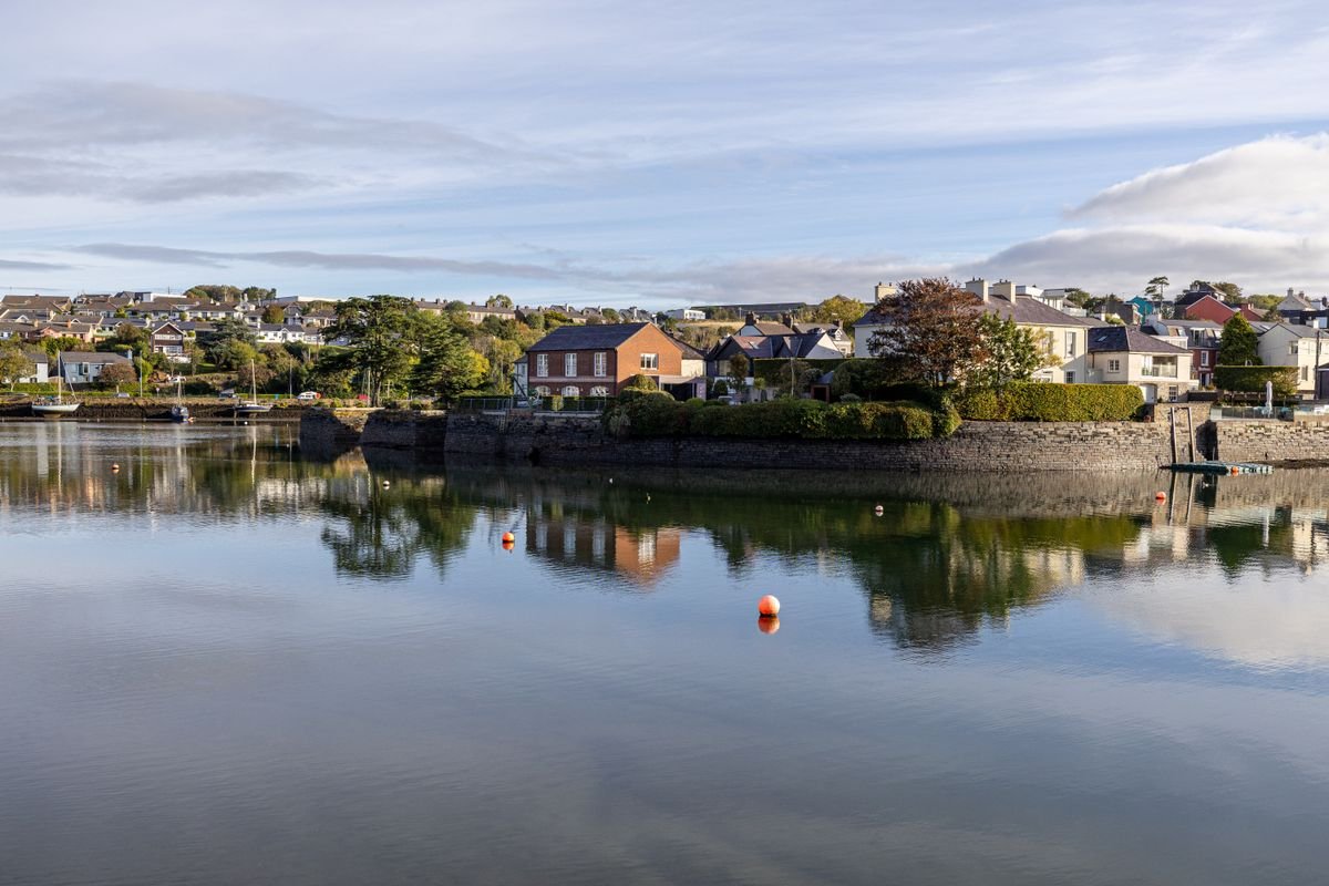 Colourful harbour houses reflected in calm water at Kinsale in County Cork