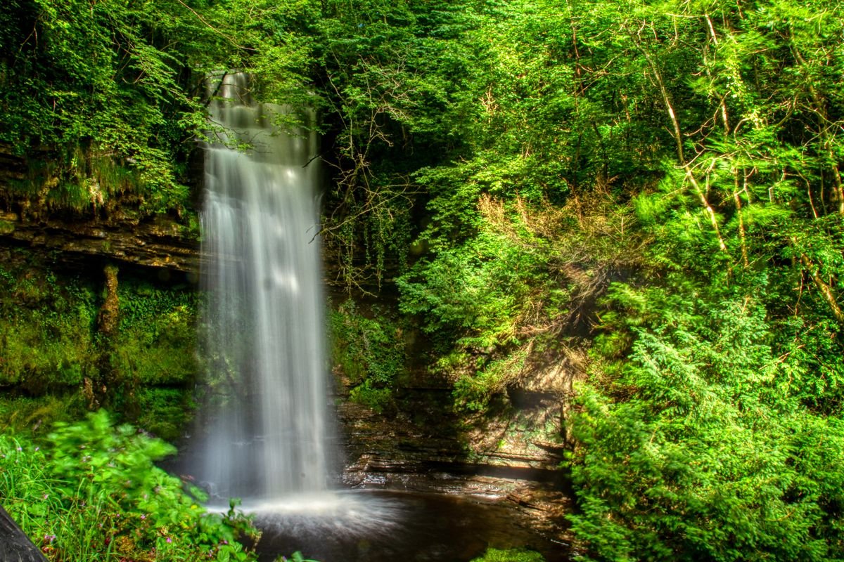 Waterfall in green forest at Glenariff Forest Park in Northern Ireland