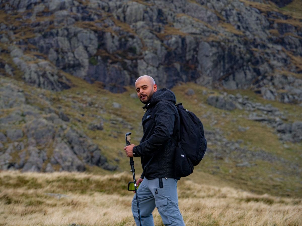 A hiker climbing an open grassy mountain slope in the Wicklow uplands
