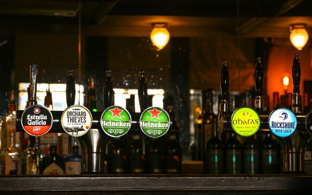 Beer taps along the bar in a dim Dublin pub interior