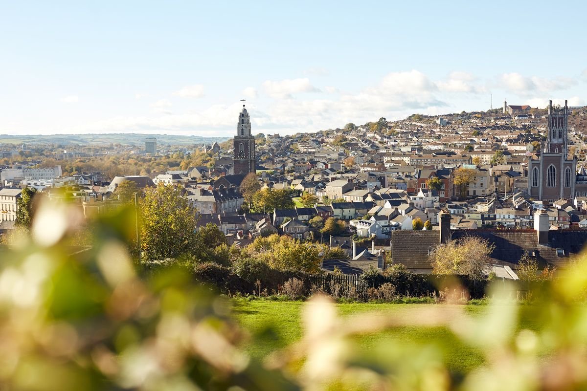 Wide view over Cork city rooftops with the Shandon tower on a sunny day