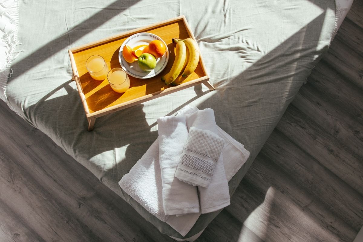 A B&B breakfast tray and fresh towels on a bed