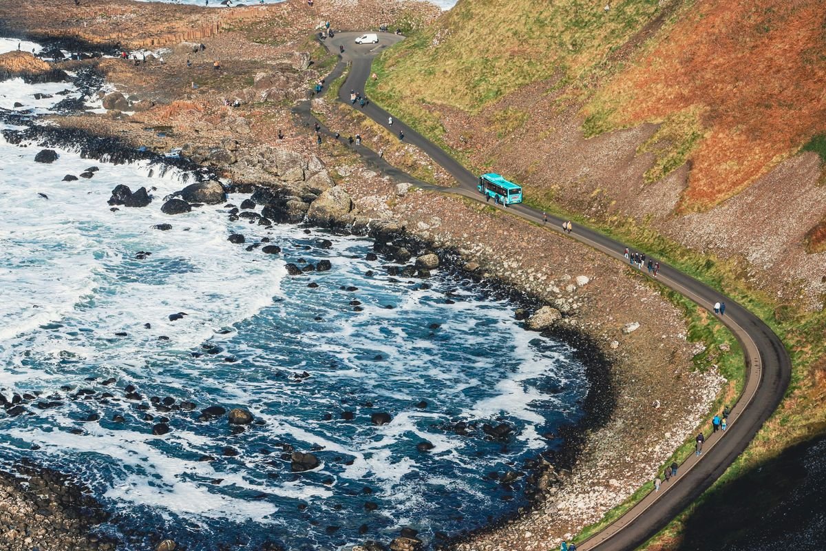 A tour coach on the Causeway Coast road above the sea near Carrick-a-Rede
