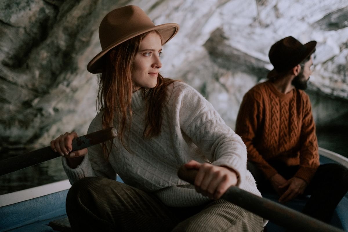Two people wearing cream and rust cable-knit Aran wool sweaters