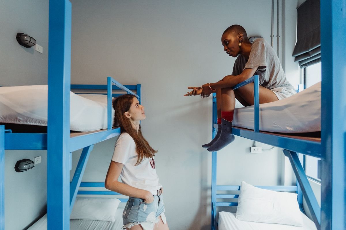 Hostel dorm room with bunk beds and travelers