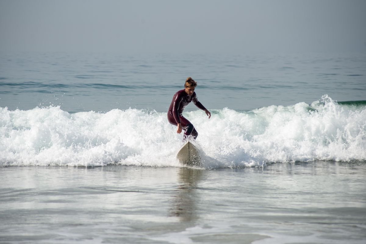 Surfer riding a breaking wave in a wetsuit off the Irish coast