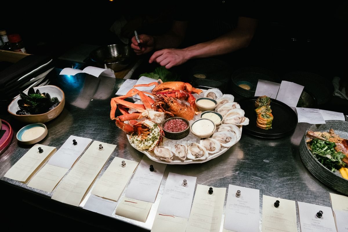 A seafood platter with lobster crab and oysters on ice