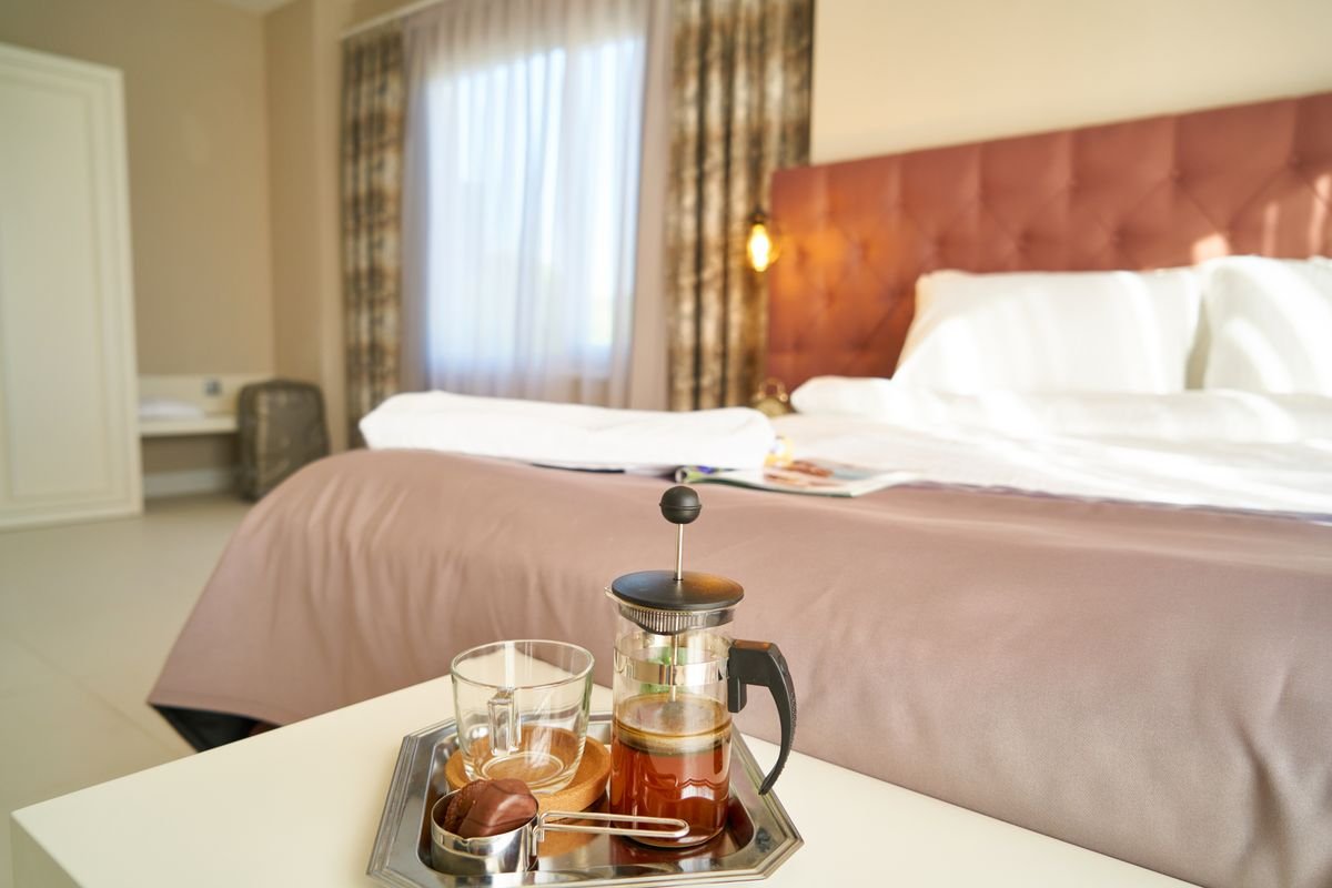 A guesthouse bedroom with a made bed and a tray of tea