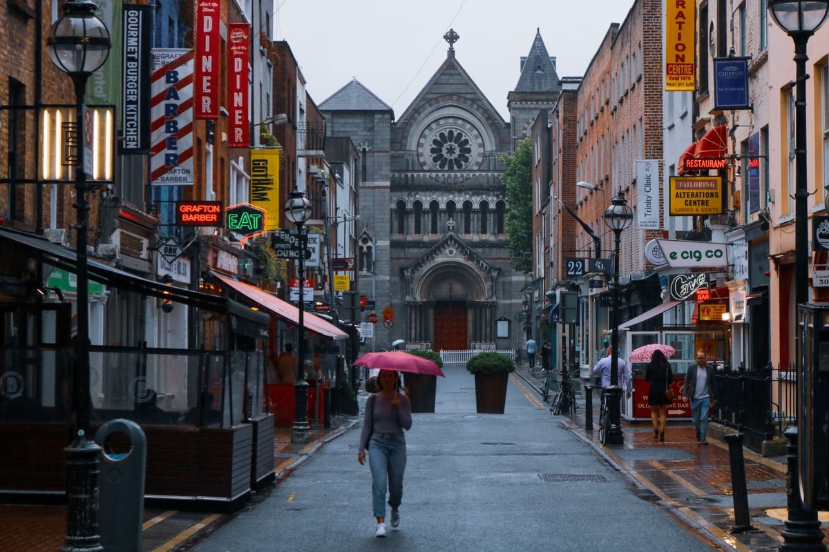 A rainy Dublin street with people walking under umbrellas