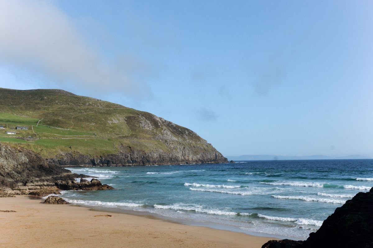 Cross Beach on the Mullet Peninsula in Mayo, soft sand and gentle waves below a green headland