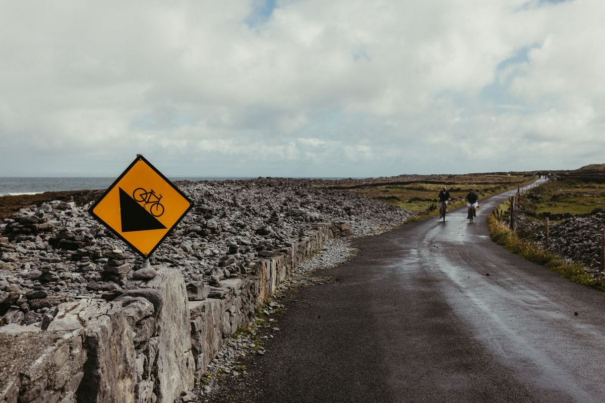 A narrow Irish coastal road between stone walls with the sea beyond