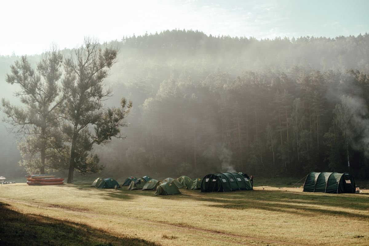 Tents pitched in a green field on a misty morning, camping near the Dingle coast