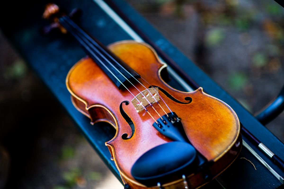A fiddle and bow resting on a bench